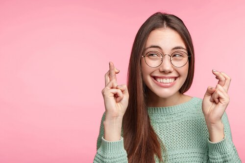 femme qui croise les doigts pour avoir de la chance
