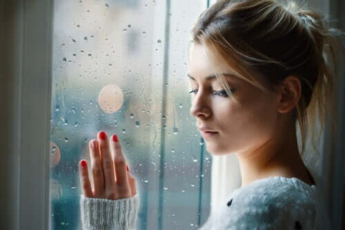 femme triste à la fenêtre devant apprendre à lâcher prise