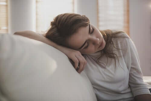 Une femme qui dort contre son canapé