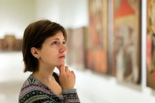 Une femme observe un tableau