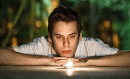 Un homme qui regarde une bougie