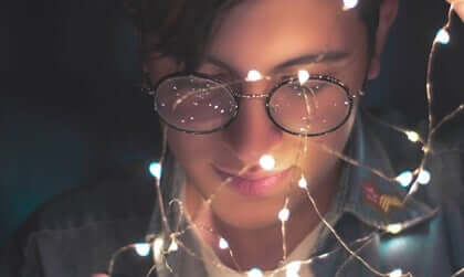 Un homme qui regarde une guirlande lumineuse