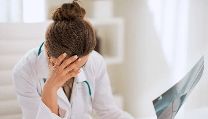Une femme en blouse atteinte du syndrome de l'épuisement professionnel