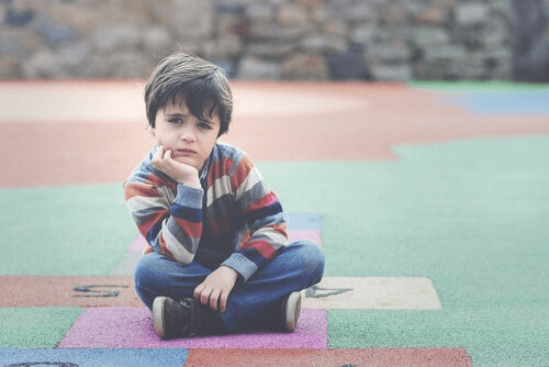 Un enfant est assis dans une cour de récréation