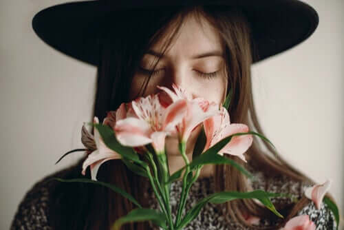 Une femme sentant des fleurs grâce à son bulbe olfactif