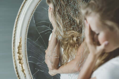 Une femme face à un miroir cassé 