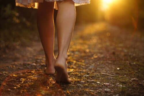 Les pieds d'une femme en deuil sur un chemin