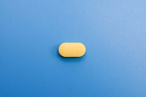 Une pilule jaune sur fond bleu