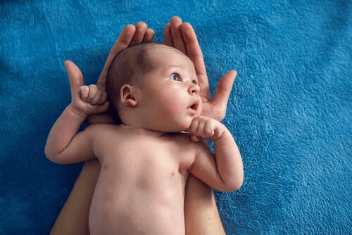 Un bébé dans les mains d'un adulte