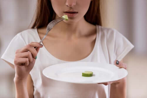 Une femme qui mange un concombre