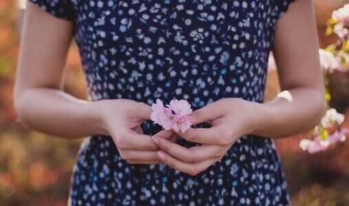 Des mains qui tiennent une fleur, ce qui veut dire "pardonne-moi"