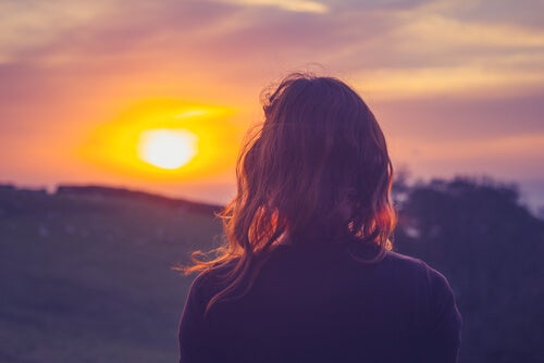 Une femme face à un coucher de soleil