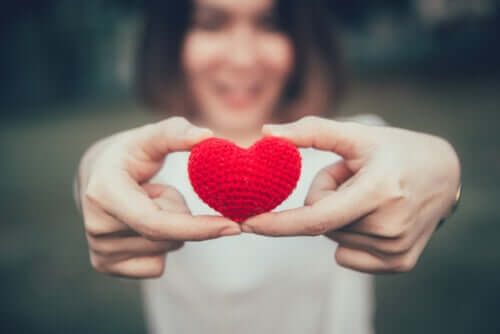 Une femme tenant un coeur dans ses mains qui représente l'estime de soi