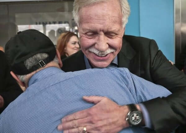 Sully, le capitaine du miracle d'Hudson, prenant un passager dans ses bras