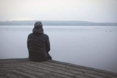 Un homme assis devant un lac