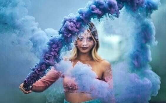 Une femme entourée de fumée bleue.