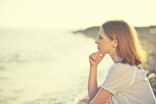 Une femme réfléchissant face à la mer