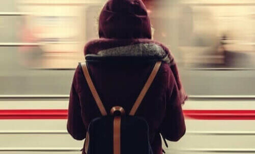 Un train passe devant une femme