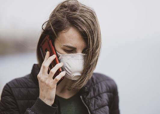 Une femme avec un masque au téléphone