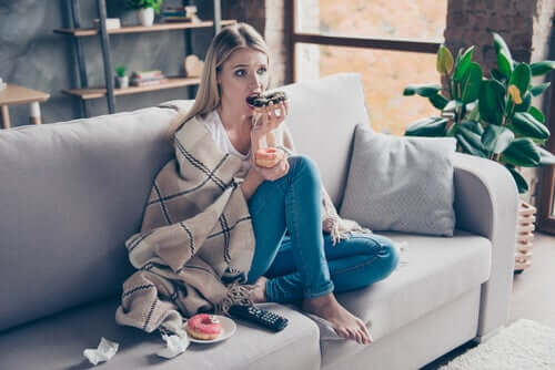 Une femme en train de manger des donuts du fait du lien stress et alimentation