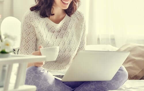 Une femme sur son ordinateur en pyjama