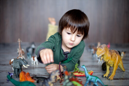 Un enfant ayant de hautes capacités intellectuelles jouant avec des dinosaures