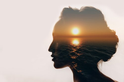 Une femme en transparence devant un coucher de soleil