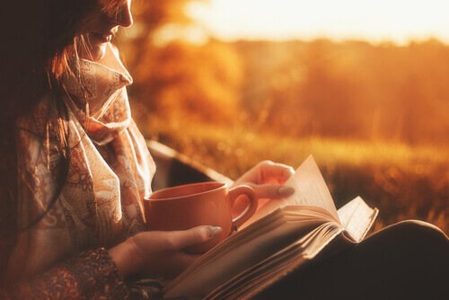 Une femme lisant un livre au coucher du soleil