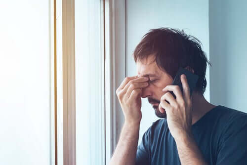 Un homme anxieux au téléphone.