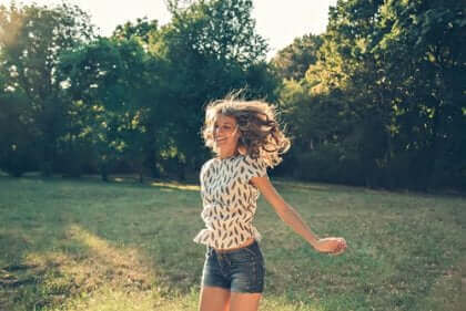 Une femme courant dans un champ heureuse.