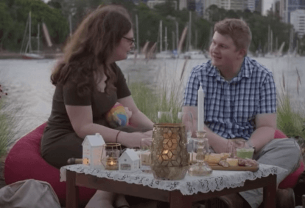 Un couple qui déjeune au bord d'une rivière. 