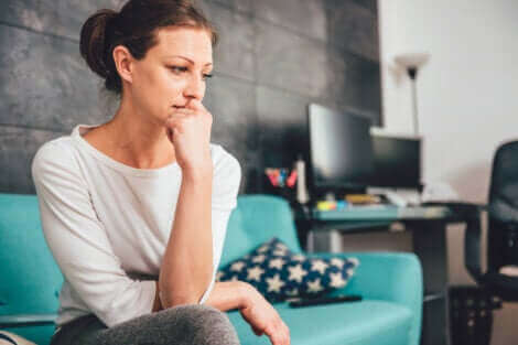 Femme anxieuse assise sur un canapé.