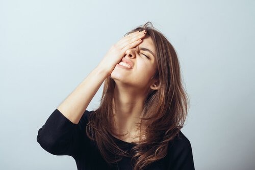Une femme énervée, la main contre la tête. 