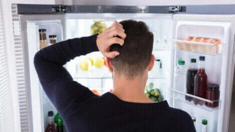 Un homme qui regarde la nourriture dans son réfrigérateur.