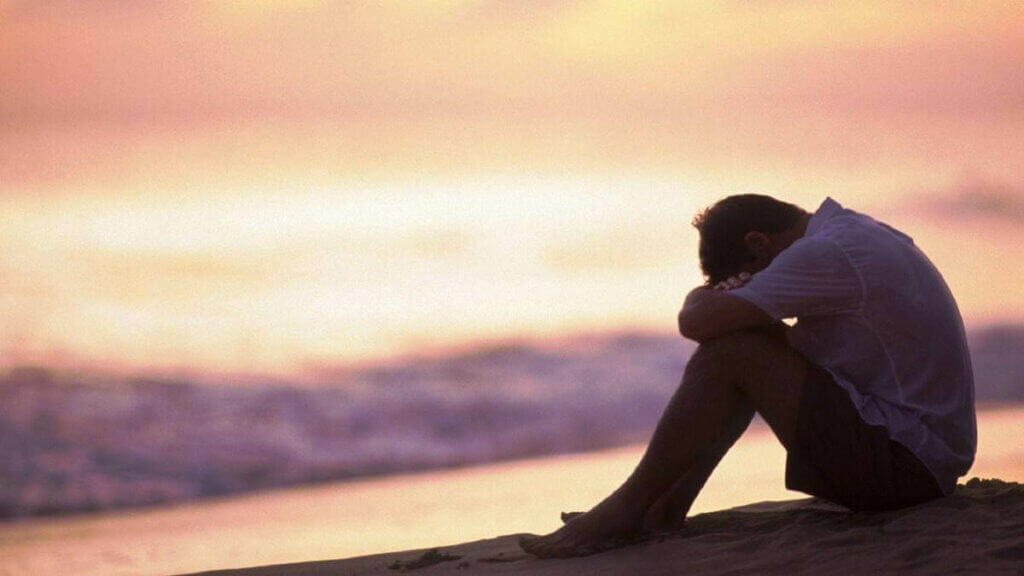 Un homme triste face à la mer. 