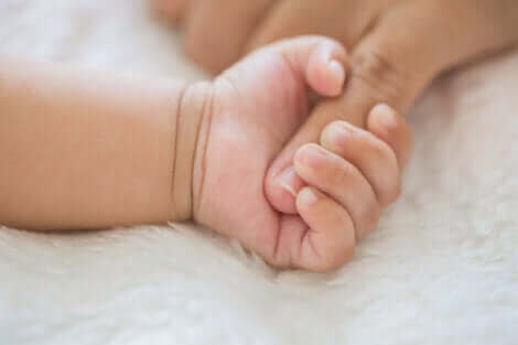 La main d'un bébé qui serre le doigt de sa mère.