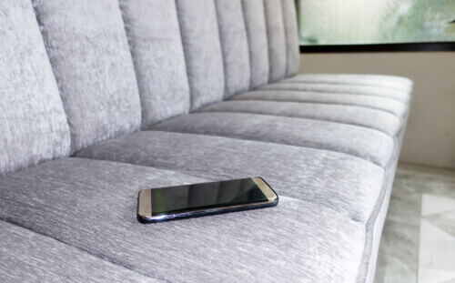 Un téléphone portable posé sur un canapé.