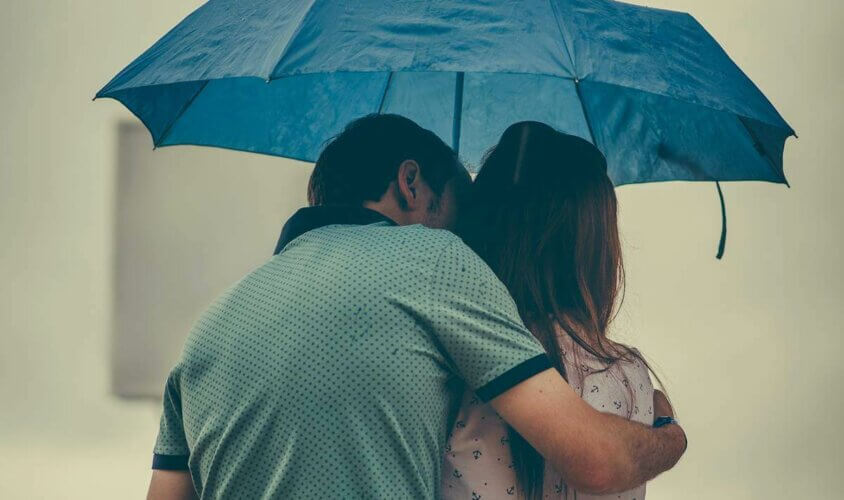 Un couple sous un parapluie.