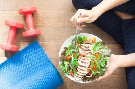 Une femme qui mange une assiette de salade. 
