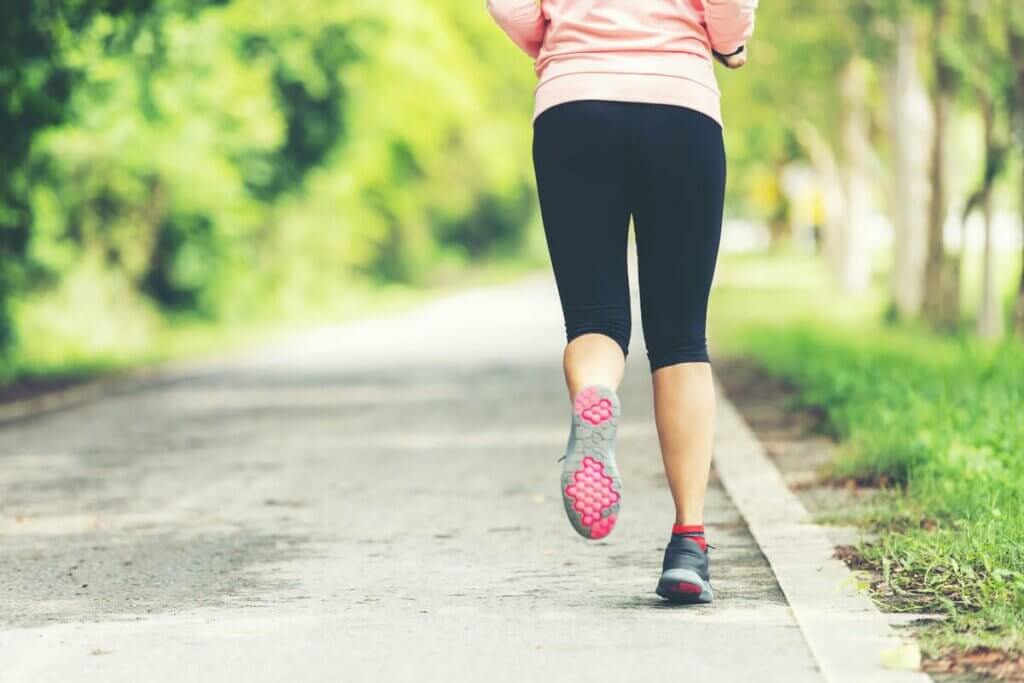 Une femme qui fait un footing en extérieur. 