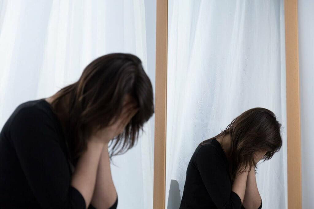 Une femme qui pleure près d'un miroir.