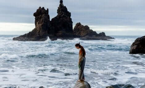 Une fille sur un rocher en pleine mer.