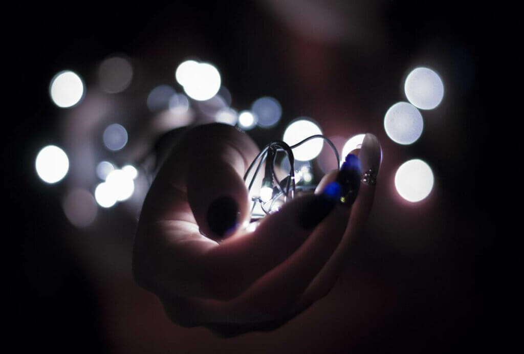 Une guirlande lumineuse dans une main. 
