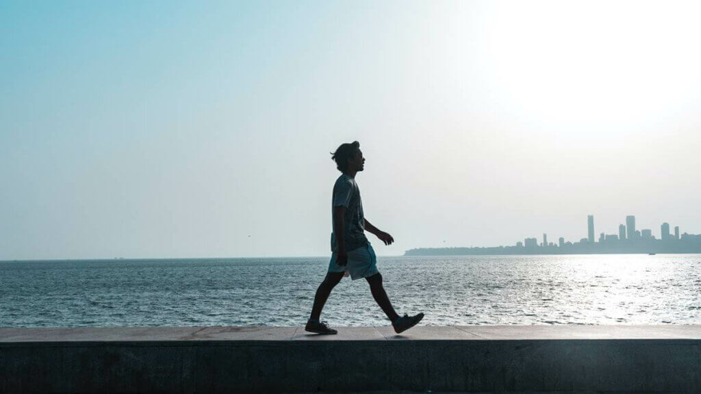 Un homme qui marche en bord de mer. 