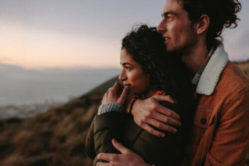 Un couple enlacé face à la mer.