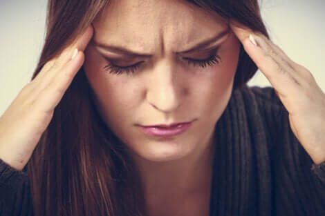 Une femme anxieuse qui a mal à la tête. 