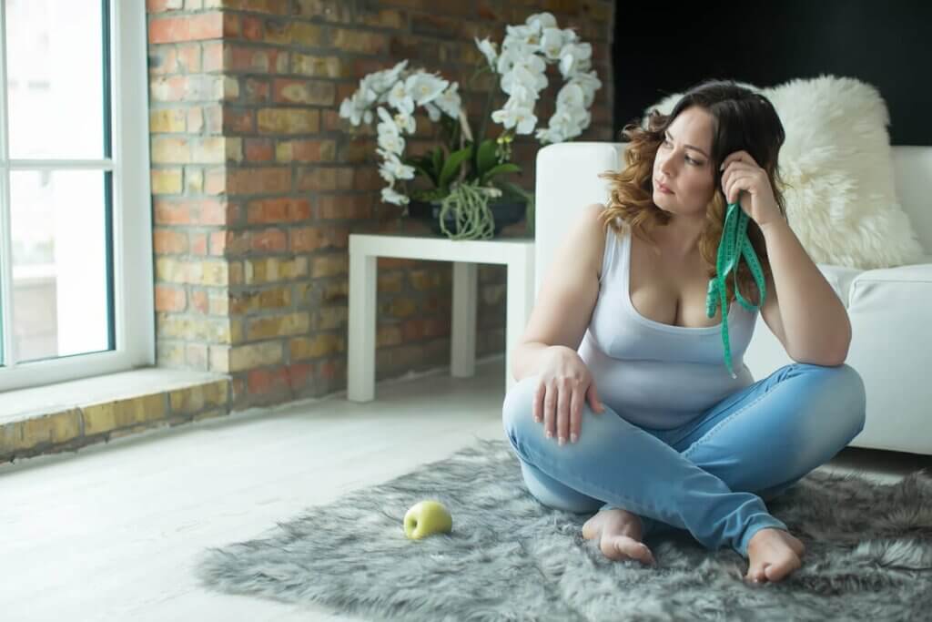 Une femme frustrée assise par terre.