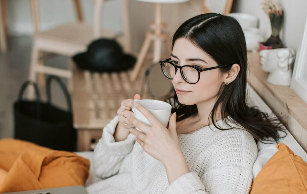 Une femme pensive sur son canapé. 