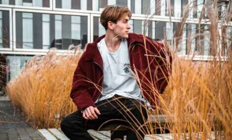 Un garçon assis sur un banc. 