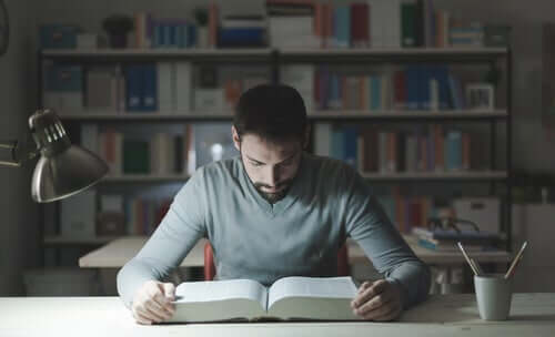 Un étudiant garçon en train de lire un livre.